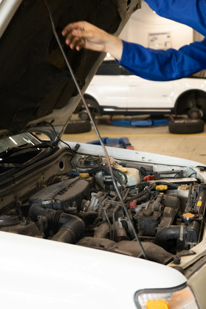 A mechanic examining the engine of an overheating car in the repair shop.